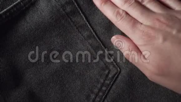 女孩摸着光滑的黑色牛仔裤检查服装店或纺织厂的织物质量视频的预览图