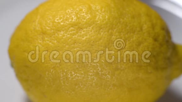 用刀子把熟黄的柠檬切成两部分的过程视频的预览图