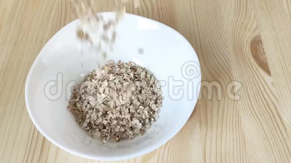 干燥的4真正的薄片倒入白色的碗烹饪健康食品早餐快速煮粥黑麦小麦大麦混合视频的预览图