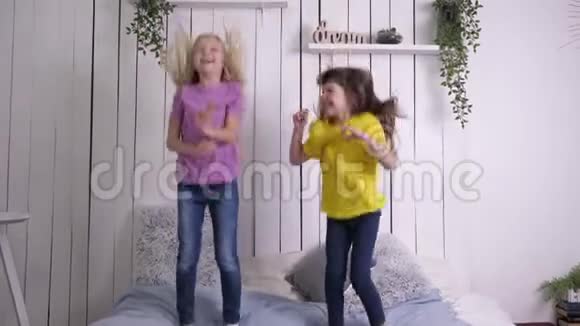快乐的童年和休闲小女朋友在家里放松的同时在床上缓慢地跳跃着视频的预览图