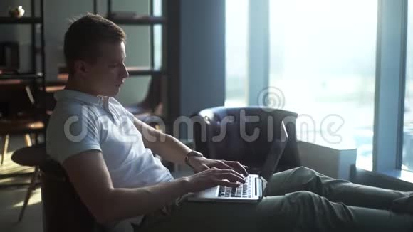 自信的年轻商人用笔记本电脑把脚放在咖啡桌上视频的预览图
