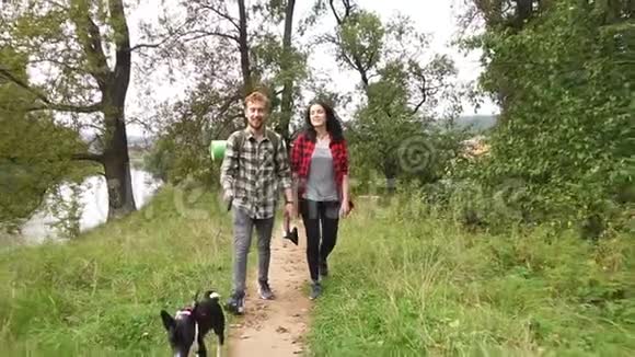 年轻夫妇的游客穿过美丽的森林视频的预览图