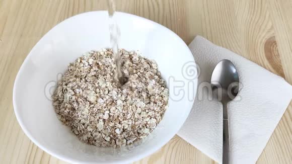 白碗中干燥的4真薄片用热水倒入烹制健康食品早餐即食粥混合黑麦视频的预览图