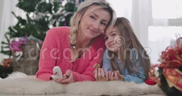 一个年轻的白种人女人和一个正在吃饼干的黑发女孩交谈妈妈和女儿度过圣诞夜视频的预览图