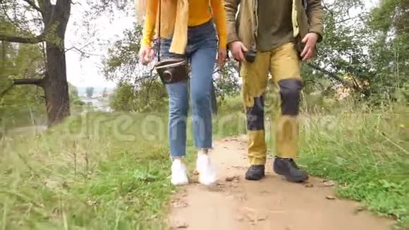 一对年轻夫妇背着背包在林间小路上散步视频的预览图