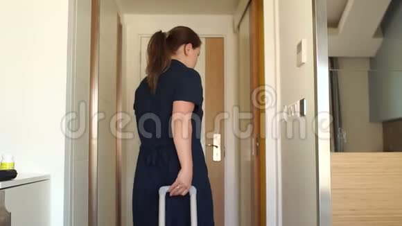 一个女孩带着手提箱在酒店房间里她拿出房间钥匙离开视频的预览图