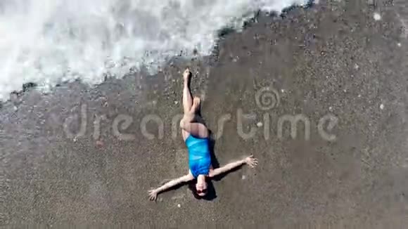 女人躺在沙滩上海水冲刷着她视频的预览图