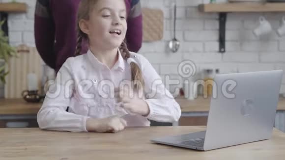 可爱的白人女青少年看着笔记本电脑屏幕手抱着头面带微笑的照片漂亮的女孩视频的预览图