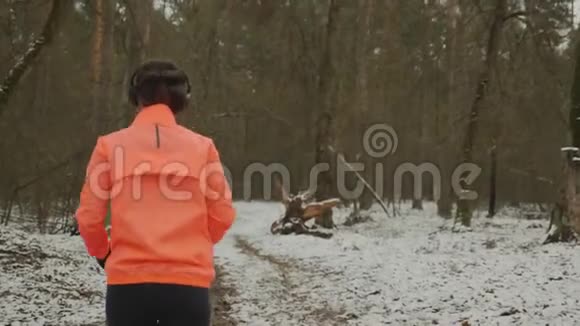女性在冬季森林慢跑年轻女子跑公园减肥女孩在孤立的森林里进行激烈的训练女人辛苦了视频的预览图