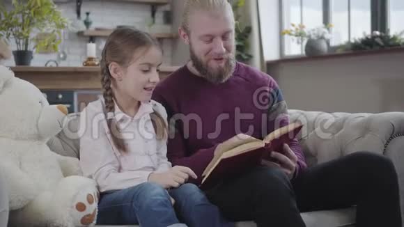 与十几岁的女儿一起看书的快乐白种人的特写有辫子的可爱女孩花空闲时间视频的预览图