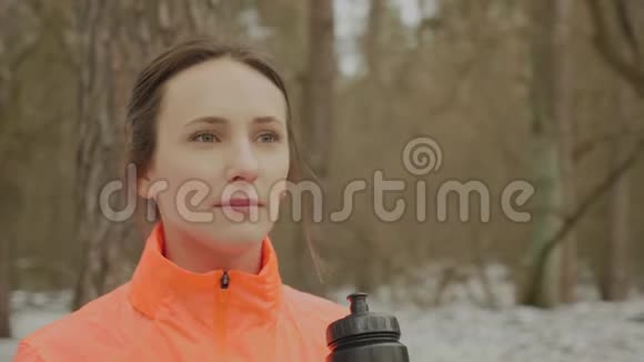 女性饮水画像年轻自信的女孩跑步后从公园的瓶子里喝水女运动员恢复视力视频的预览图