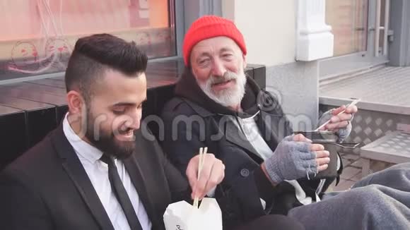 时尚的上班族和乞丐男性坐在街上吃饭说话视频的预览图