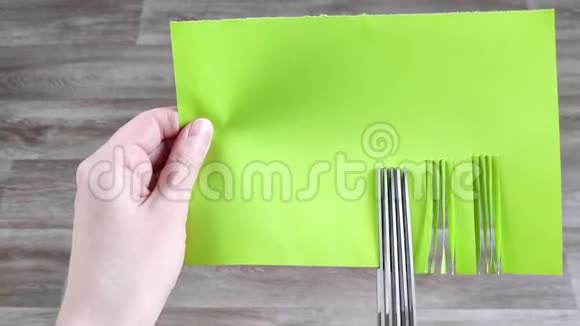 草药剪刀剪绿纸多层剪刀切割蔬菜特写木制背景视频的预览图