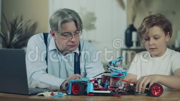 一个男孩和他爷爷正在一起组装玩具车视频的预览图