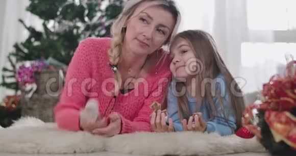 年轻的金发白种人女人和黑发女孩躺着头靠近对方说话的肖像母亲和视频的预览图