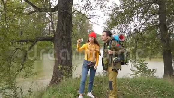 年轻迷人的情侣游客在秋天的森林里自拍视频的预览图