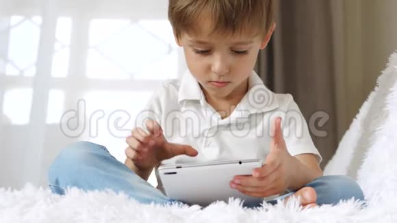 小男孩在平板电脑的帮助下热情地玩耍视频的预览图