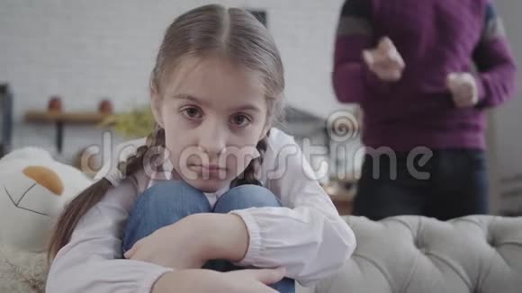 美丽的白种人十几岁的女儿抱着膝盖看着镜头无法辨认的父亲视频的预览图