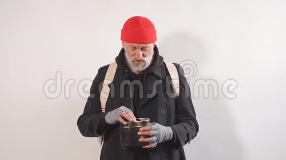 无家可归的乞丐用杯子买钱的肖像在他的杯子里找到纸币视频的预览图