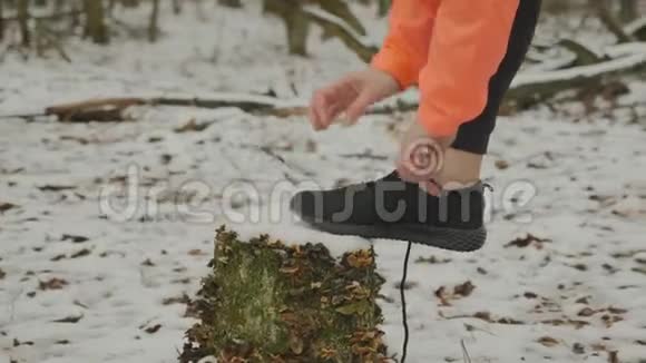 系鞋带的手指女手在公园里的运动鞋上系鞋带特写女人系鞋带准备逃跑女孩视频的预览图