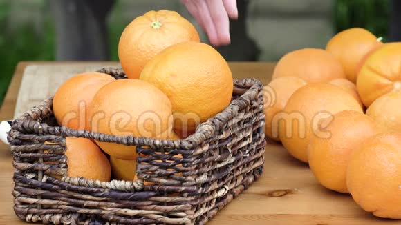 新鲜成熟的橘子贴在花园的木桌上女人切橘子视频的预览图