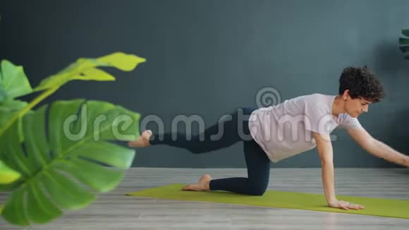 苗条的女人在室内做瑜伽在垫子上的健康中心专注于身体护理视频的预览图