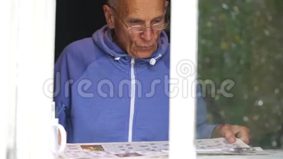 退休男子通过窗户观看填字游戏视频的预览图