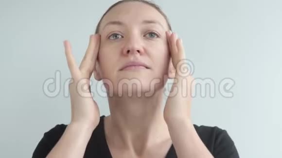 一个漂亮的女人在她的皮肤上涂上抗皱保湿油视频的预览图