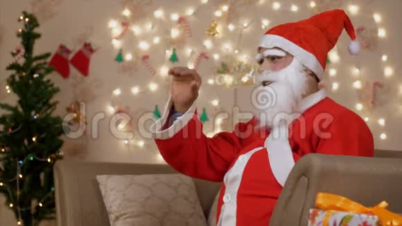 一个小男孩坐在圣诞老人腿上得到圣诞礼物视频的预览图