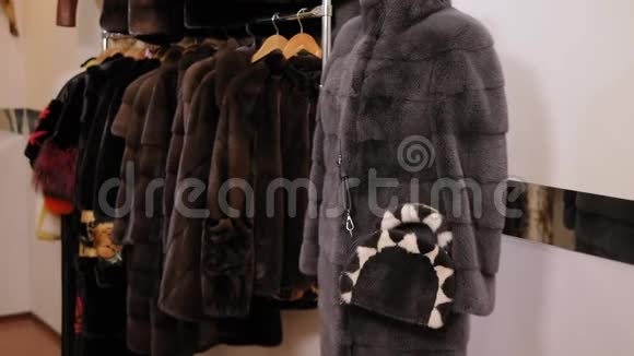 在毛皮店的衣架上有不同颜色的漂亮毛皮外套慢节奏视频的预览图