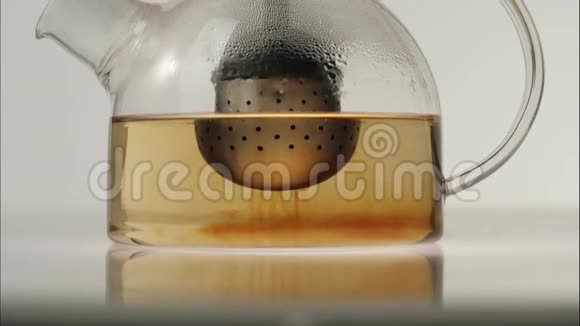 茶道红茶是在沸水中冲泡的在白色桌子上的透明壶中以白色为背景时间流逝视频的预览图