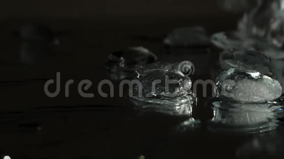 冰块被扔在镜子上它们用喷雾和水向不同的方向移动视频的预览图