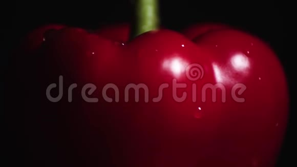 在黑色背景上旋转的红铃椒视频的预览图