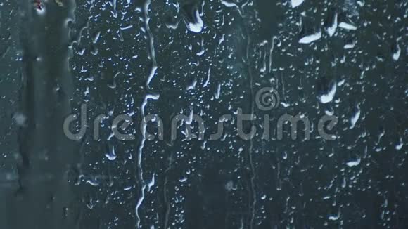 在暴风雨的天气里窗玻璃和雨滴滑落下来视频的预览图