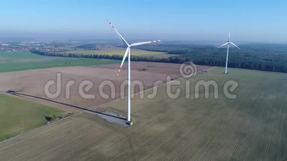 在田野里的两个风车附近飞行从空中向直升机拍摄视频视频的预览图