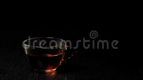 茶道冰块掉进透明的杯子里黑底黑桌上放着水果红茶视频的预览图