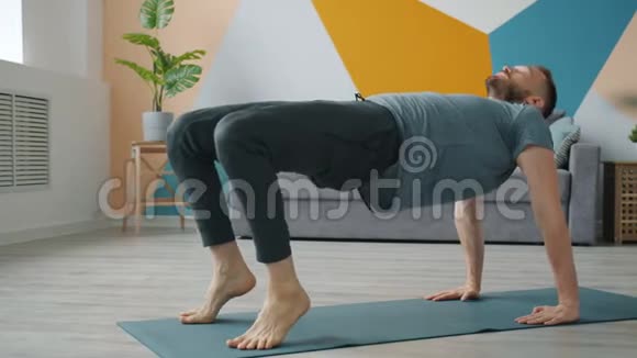 强壮的男人在家锻炼在瑜伽垫上穿运动服视频的预览图