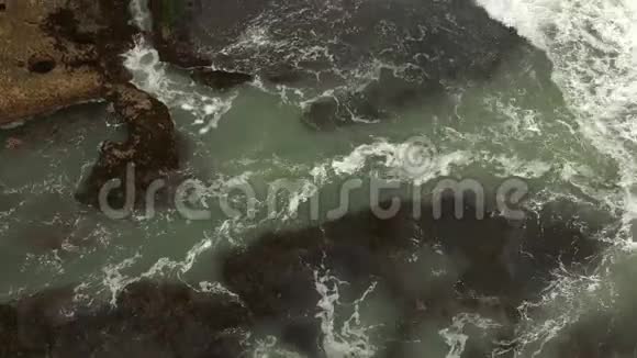 高空俯视海浪在海滩附近的暗礁上破碎在美丽的海滩上的岩景上海浪海浪视频的预览图