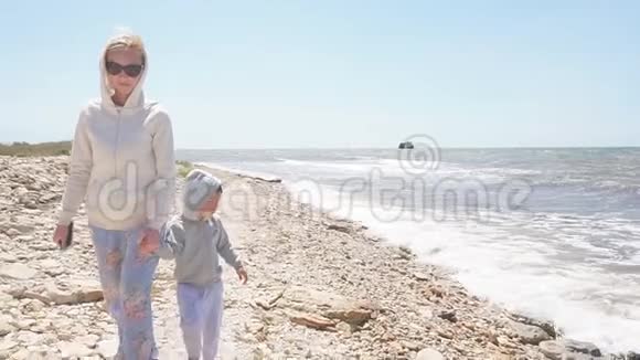 一家人在岩石海岸散步的慢镜头视频的预览图