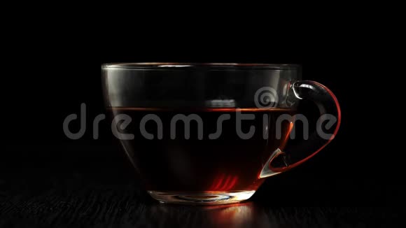 茶道白牛奶倒入一个透明的杯子里红茶在黑底的黑桌上溅满视频的预览图
