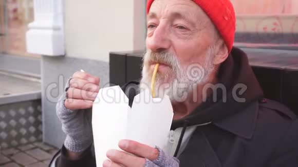 年老的流浪汉坐在街上饿着肚子吃饭视频的预览图