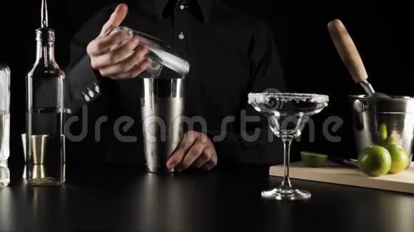 经典玛格丽塔鸡尾酒酒保从波士顿摇床上拿出一个杯子把它包在边缘放在桌子上视频的预览图