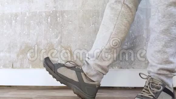 女孩穿着灰色裤子站在地板上穿着运动鞋伸展着腿和脚的肌肉健身用运动鞋视频的预览图