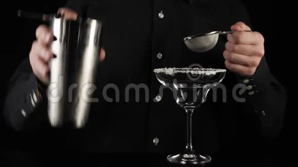 经典玛格丽塔鸡尾酒酒保把一个过滤器放在摇床上然后把一个鸡尾酒从另一个过滤器倒入玻璃杯中视频的预览图