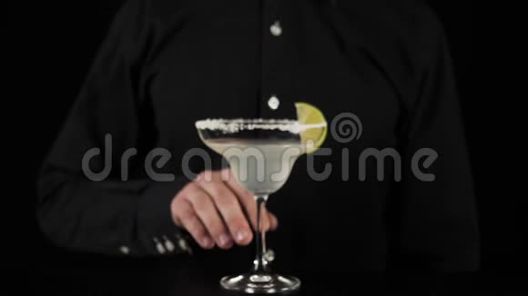 经典玛格丽塔鸡尾酒调酒师的手掌从一个杯子上取下玛格丽塔杯边放一片石灰以品尝鸡尾酒视频的预览图