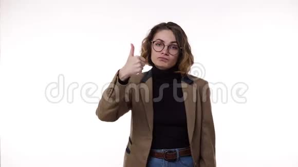 年轻的白种人女人穿着黑色的夹克和棕色的夹克用大拇指做手势然后举手视频的预览图