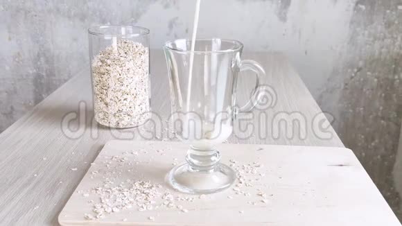 牛奶放在透明杯里有手柄燕麦片放在罐子里纯素替代奶牛乳制品不透明奶油饮料视频的预览图