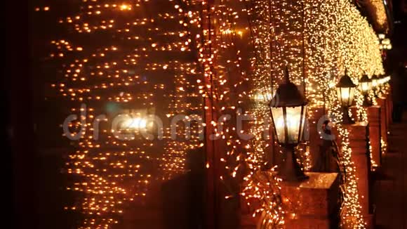 圣诞夜街灯上闪烁的金色灯光模糊视频的预览图