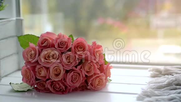 一束玫瑰花放在木制窗台上有城市背景和过往的汽车视频的预览图