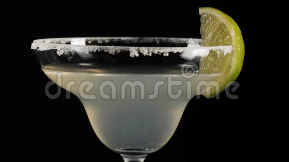 经典玛格丽塔鸡尾酒一滴新鲜的柠檬汁随着鸡尾酒流在玻璃杯的边缘玛格丽塔酒的概念视频的预览图